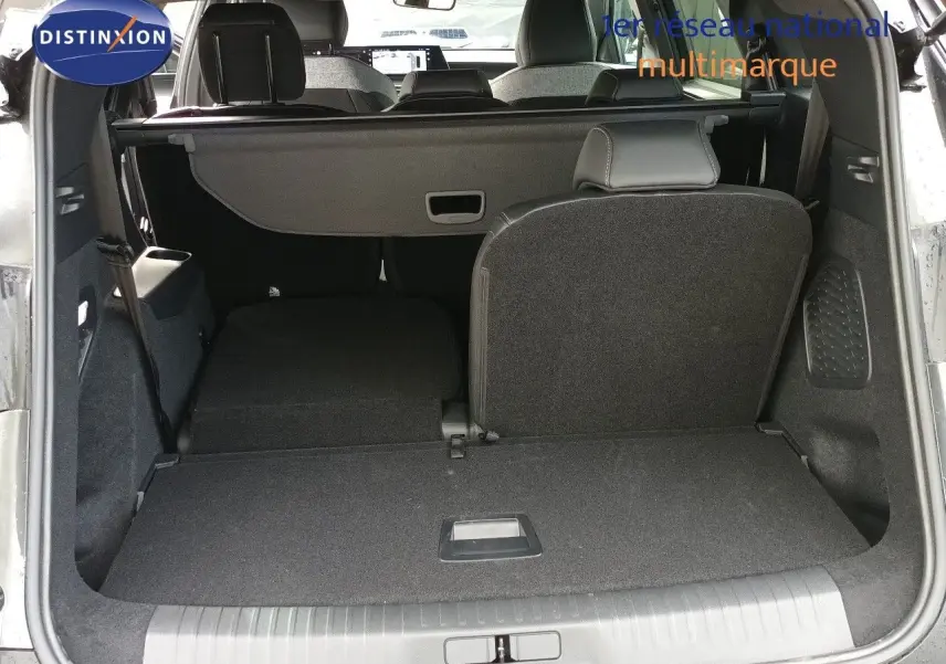 Vue arrière du coffre ouvert du Peugeot 5008 gris titane, montrant la banquette arrière partiellement rabattue.