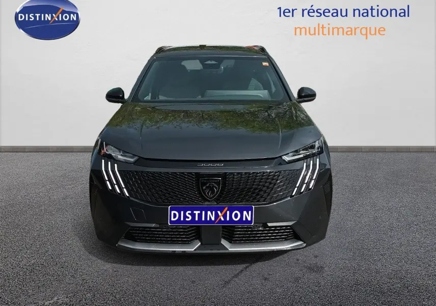 Vue avant d’un Peugeot 5008 gris titane métal avec calandre noire et feux LED distinctifs en griffes.