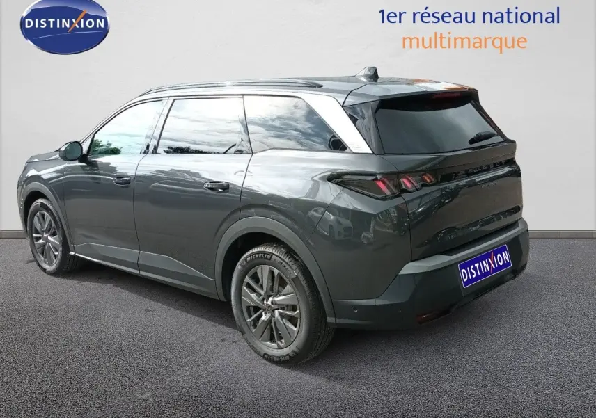 Peugeot 5008 gris titane métal en 3/4 arrière droit, SUV hybride avec jantes alliage et vitres teintées.