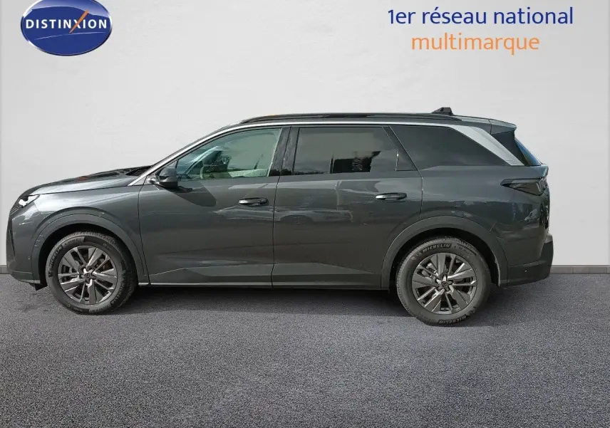 Peugeot 5008 gris titane métal vue de profil côté gauche, SUV hybride 2025 avec jantes alliage et toit panoramique.