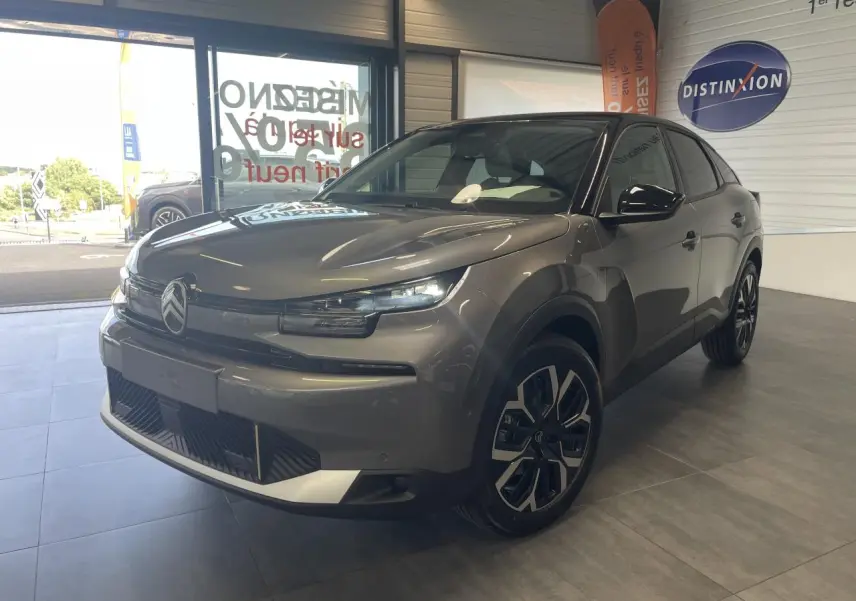 Citroën C4 gris métallisé vue 3/4 avant droit en intérieur avec toit bi-ton noir et jantes 18 pouces.