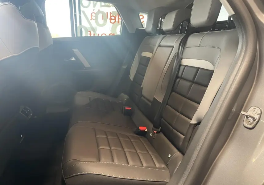 Vue intérieure côté droit sur la banquette arrière noire et grise de la Citroën C4 avec ceintures de sécurité visibles.