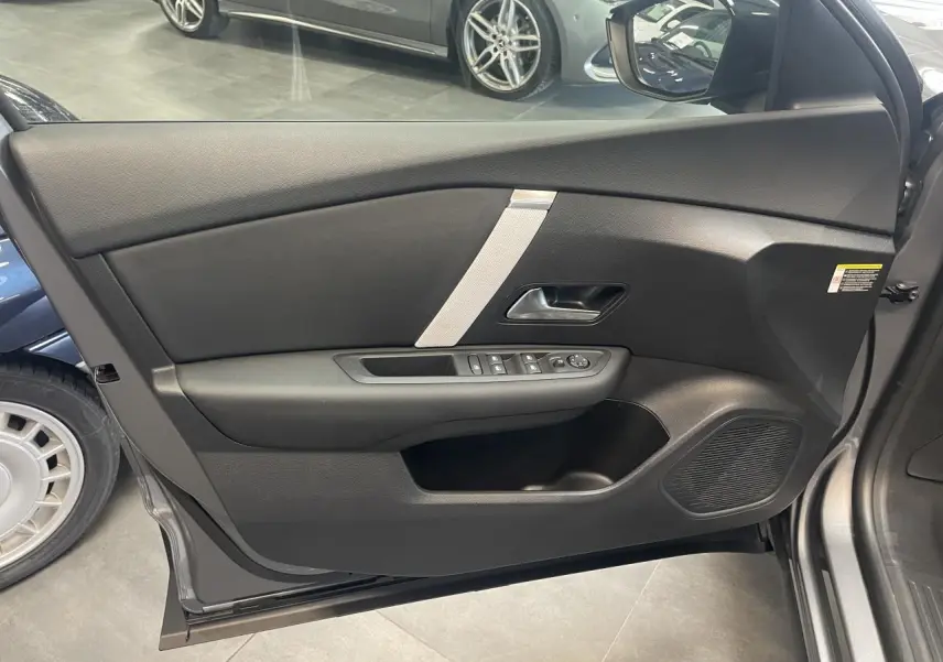 Vue latérale du panneau de porte avant gauche gris avec commandes électriques et insert décoratif clair sur Citroën C4 hybride.