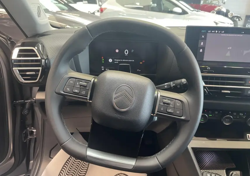 Vue rapprochée du volant cuir noir de la Citroën C4 2026 avec tableau de bord numérique et écran tactile central.