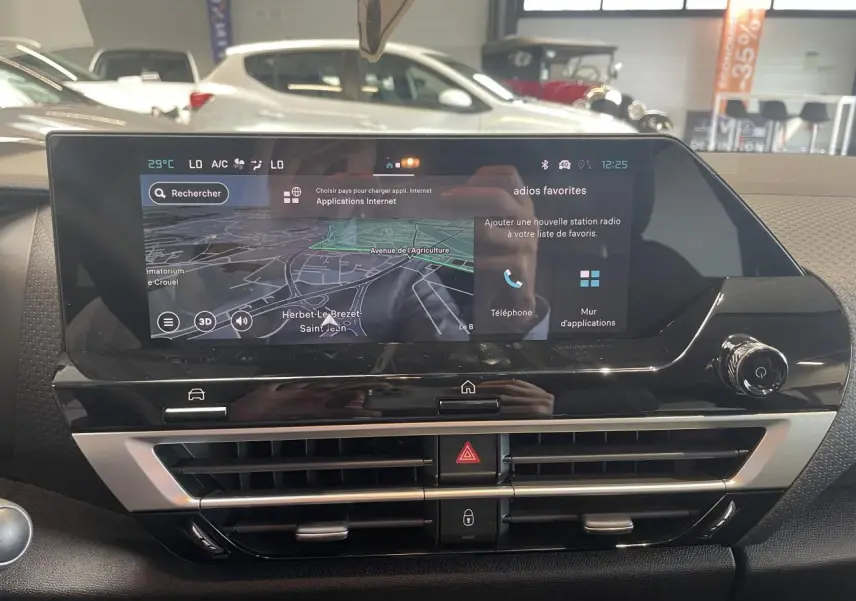 Vue rapprochée de l'écran tactile central et des aérateurs du tableau de bord de la Citroën C4 hybride gris intérieur.