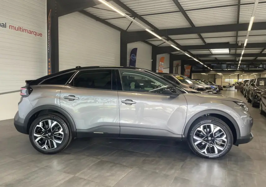 Vue latérale droite d'une Citroën C4 gris métallisé avec toit bi-ton noir et jantes alliage 18 pouces en showroom.