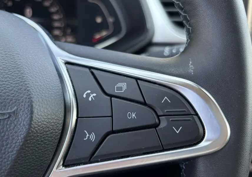 Gros plan sur les commandes multifonctions noires du volant du Renault Captur 2024, finition Techno.
