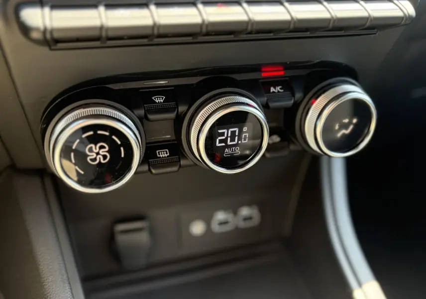 Gros plan sur les commandes de climatisation digitale du Renault Captur 2024, affichant 20°C en mode automatique.