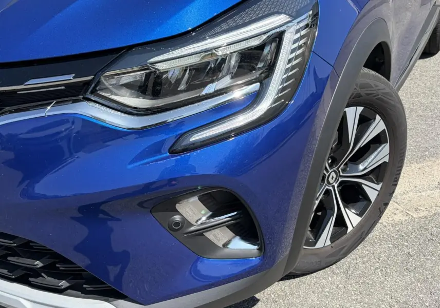 Gros plan sur l'avant droit du Renault Captur bleu Iron avec optique LED et jante alliage 17 pouces.