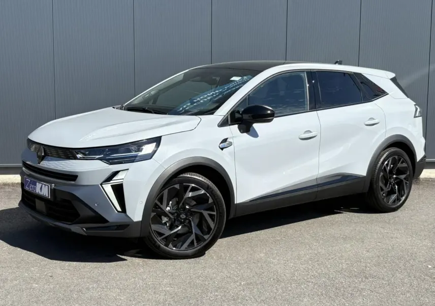 Renault Symbioz 2025 blanc vue 3/4 avant avec toit noir, jantes noires et détails modernes sur fond urbain.