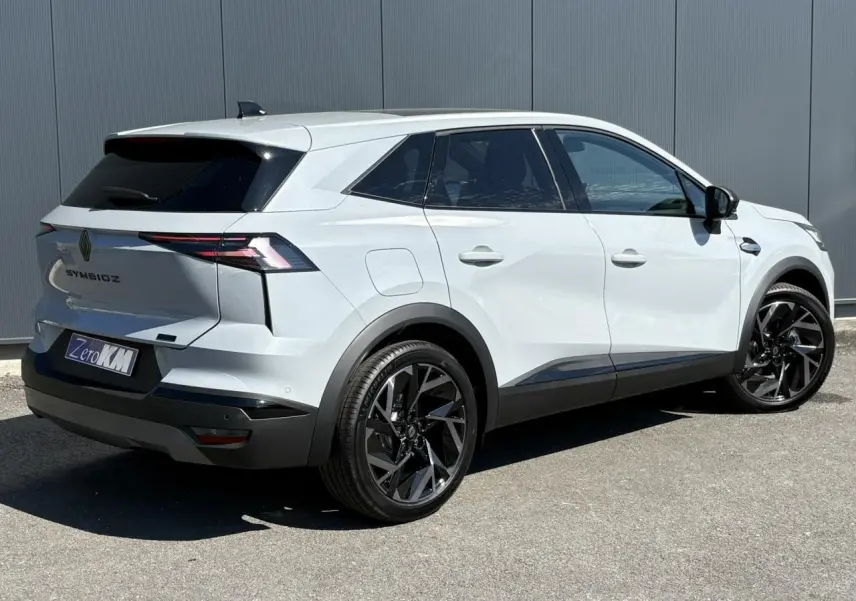 Vue 3/4 arrière droite d'un Renault SYMBIOZ gris clair avec jantes noires et vitres surteintées.