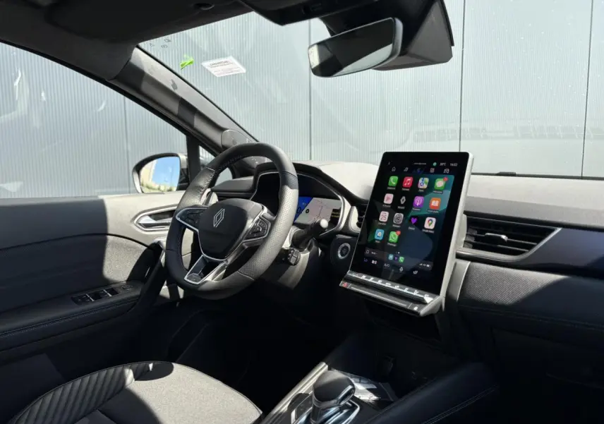 Intérieur Renault SYMBIOZ gris, vue côté conducteur sur volant, écran tactile vertical et tableau de bord moderne.