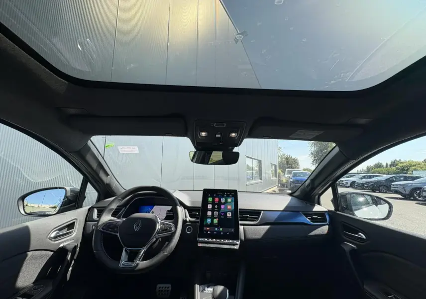 Vue intérieure avant du Renault SYMBIOZ gris Rafale avec toit panoramique Solarbay et écran tactile central.