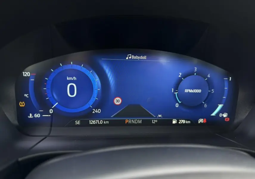 Vue rapprochée du combiné d'instrumentation numérique bleu du Ford Kuga 2023, affichant vitesse, régime et alertes.
