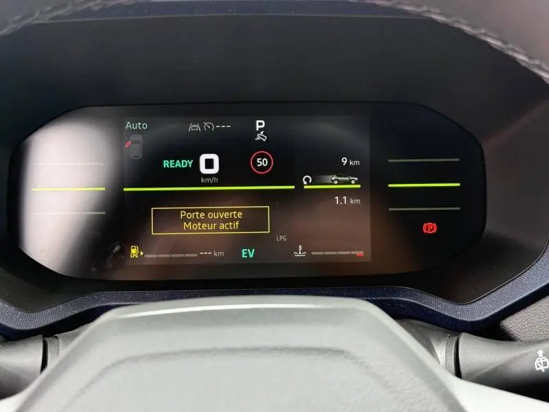 Vue rapprochée du tableau de bord numérique du Dacia Duster gris Schiste, affichant les alertes et la vitesse à 0 km/h.