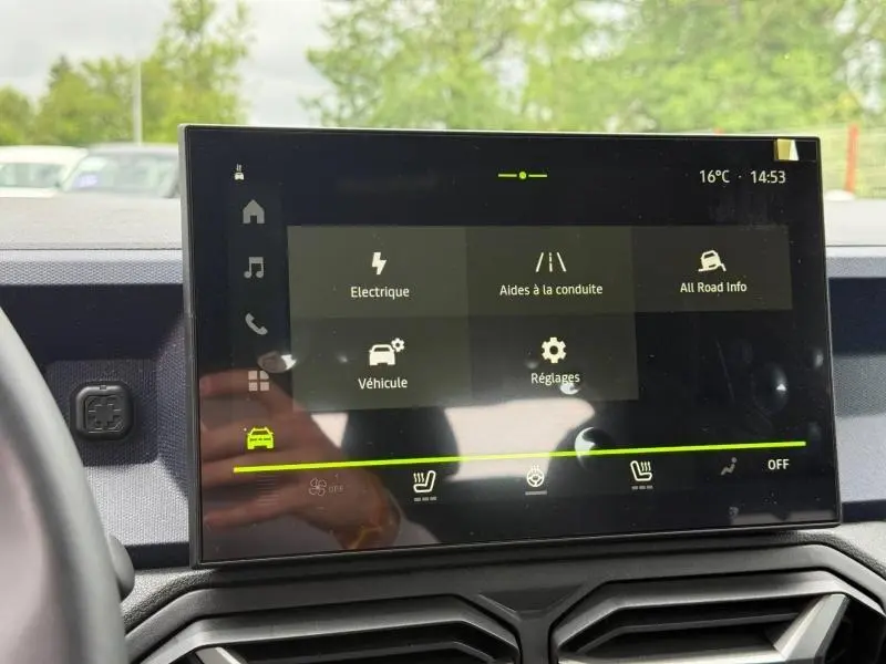Écran tactile central du tableau de bord du Dacia Duster gris, affichant les menus d’aides à la conduite et réglages.