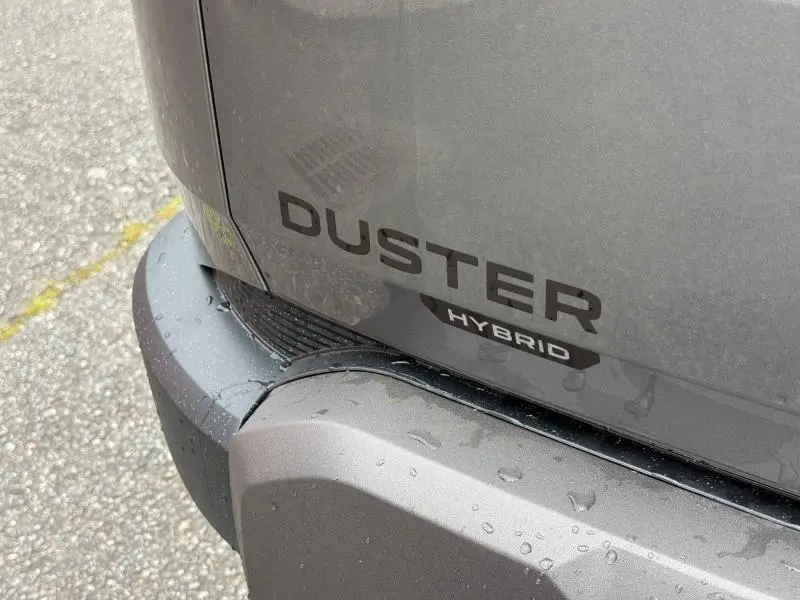 Gros plan sur l'arrière gris schiste du Dacia Duster 1.2 hybrid-G avec logo DUSTER et badge Hybrid visible.