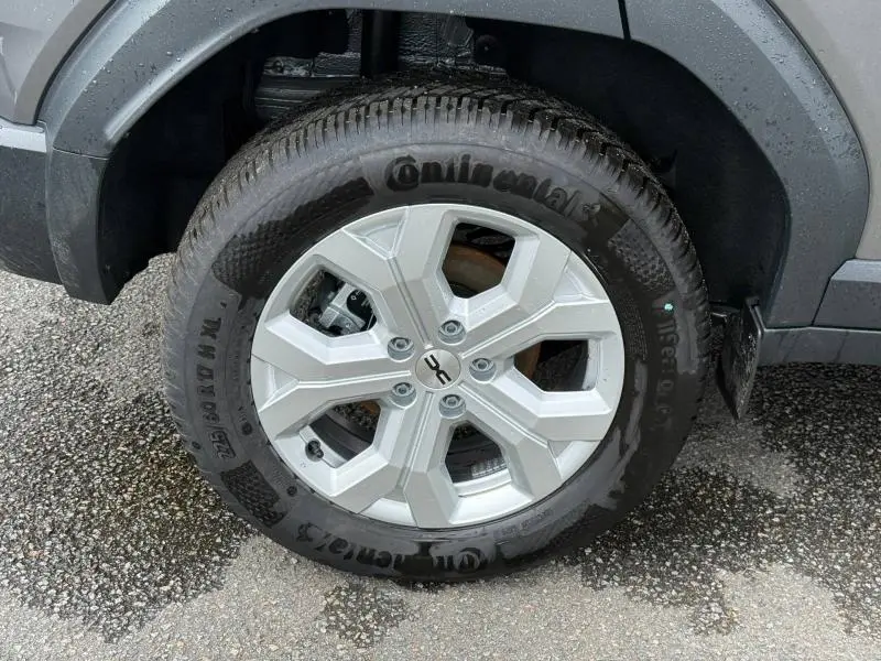 Gros plan sur la roue avant droite du Dacia Duster gris Schiste, avec jante alu et pneu Continental.