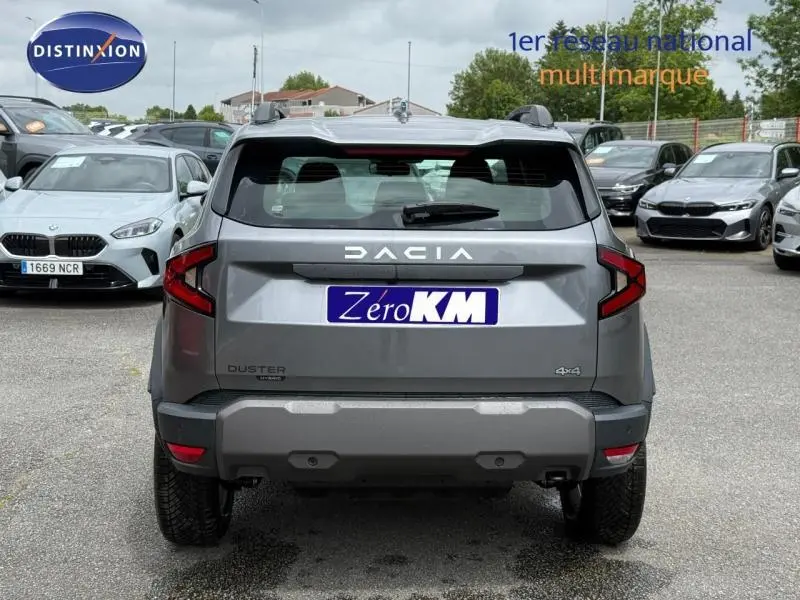 Vue arrière d'un Dacia Duster gris schiste 2026 avec logo DACIA et badge 4x4 visible sur un parking.
