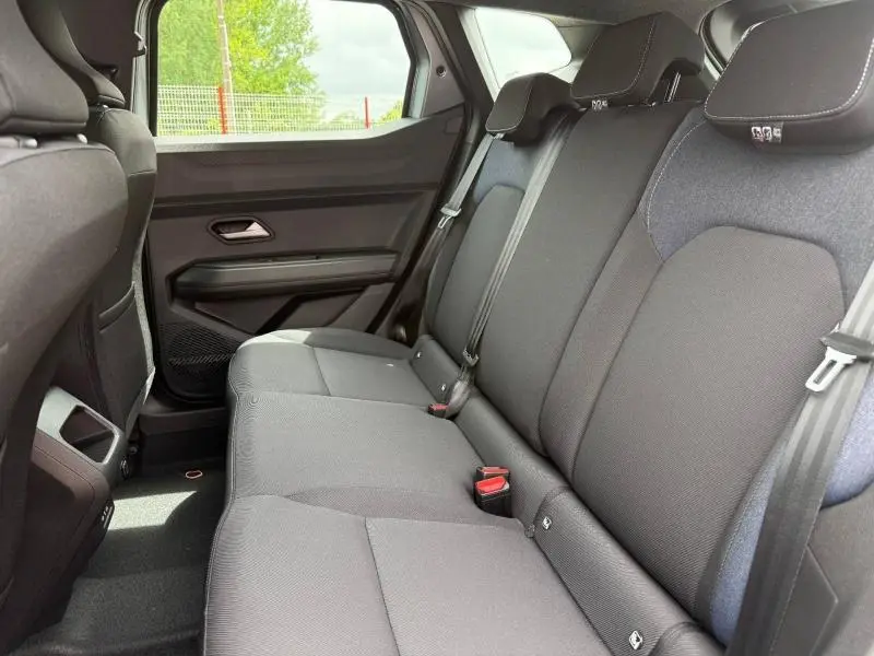 Vue côté droit de la banquette arrière noire du Dacia Duster 1.2 hybrid-G 150ch Expression 4x4 avec appuie-têtes et ceintures visibles.