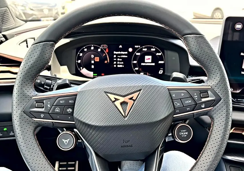 Vue rapprochée du volant cuir perforé gris et du tableau de bord digital d’une CUPRA TERRAMAR bleu fjord 2026.