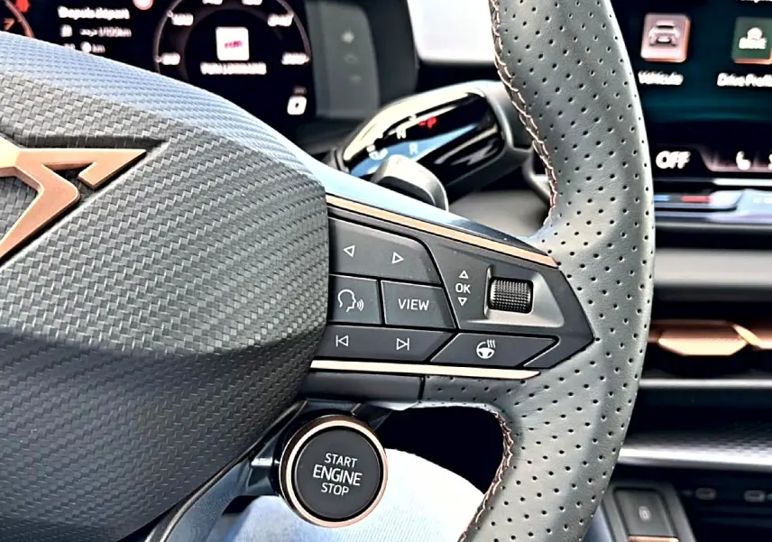 Gros plan sur le volant cuir perforé noir avec commandes multifonctions et bouton start/stop du CUPRA Terramar 2026.