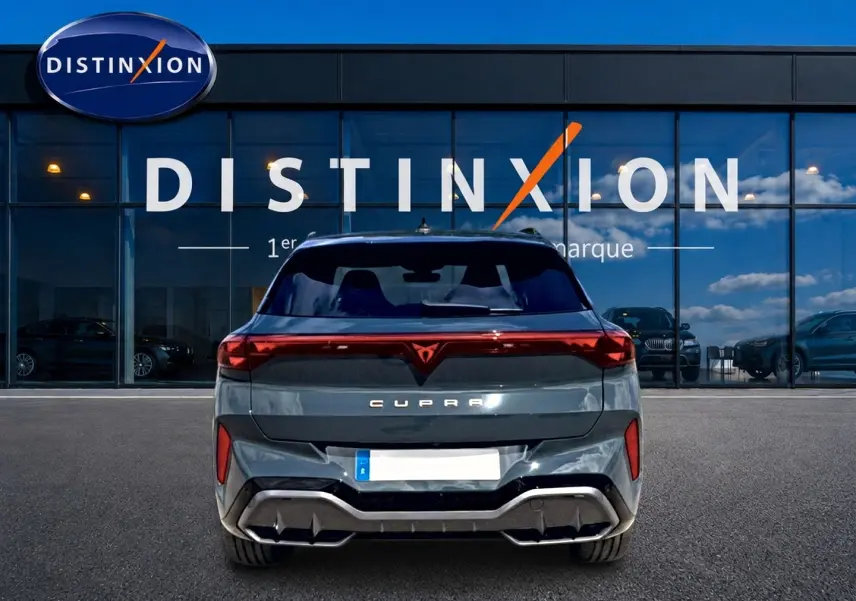 Vue arrière d'une CUPRA Terramar bleu fjord garée devant une vitrine avec logo Distinxion.