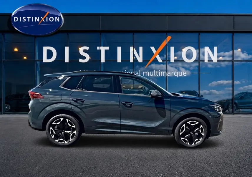 Vue latérale droite d'un CUPRA TERRAMAR 2026 bleu fjord avec jantes 19 pouces devant une vitrine Distinxion.