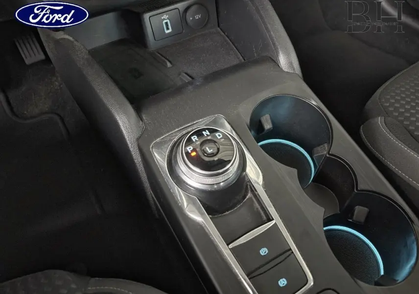 Gros plan sur la console centrale de la Ford Focus 1.5 EcoBlue 2020, avec sélecteur rotatif de boîte auto et porte-gobelets.