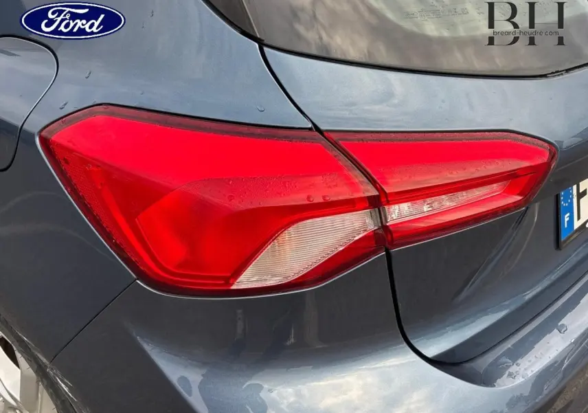 Gros plan sur le feu arrière droit d’une Ford Focus 2020 bleu azur métallisé, soulignant la teinte et les lignes du coffre.
