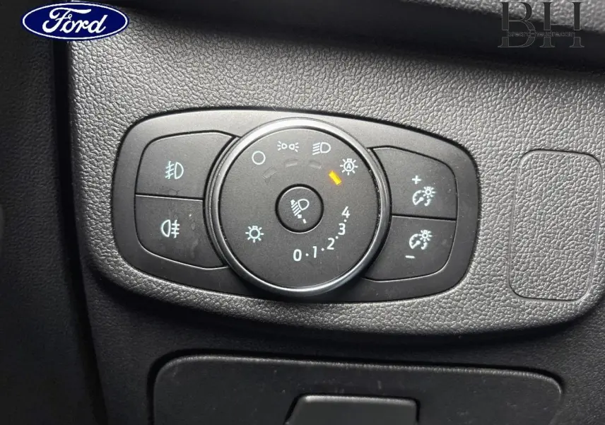 Gros plan sur la commande des phares du Ford Focus 1.5 EcoBlue 2020, tableau de bord noir texturé.