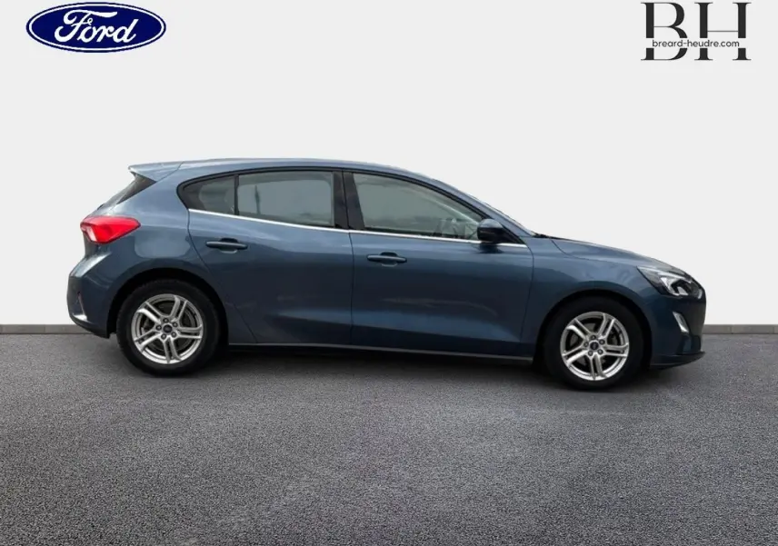 Vue de profil côté gauche d'une Ford Focus 1.5 EcoBlue bleu azur métallisé avec jantes alliage et poignées ton carrosserie.