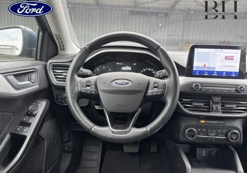 Vue intérieure centrée sur le volant cuir multifonction et l’écran tactile du tableau de bord de la Ford Focus 2020.