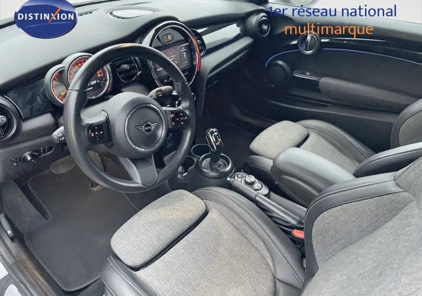 Intérieur de la MINI Cabriolet F57 2023, vue côté conducteur, sièges tissu gris et cuir noir, tableau de bord moderne.