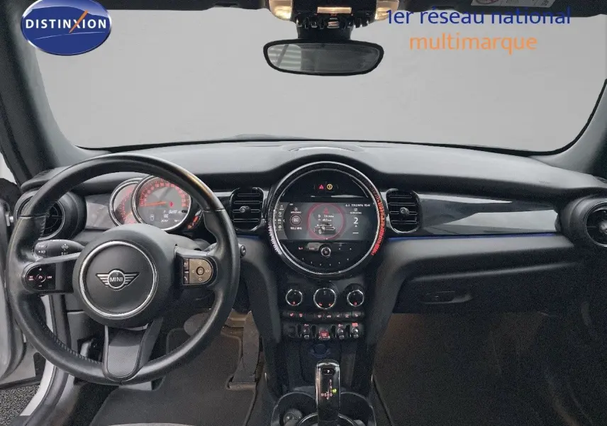 Vue frontale de l'habitacle du MINI Cabriolet Melting Silver, avec tableau de bord et volant noir visible.