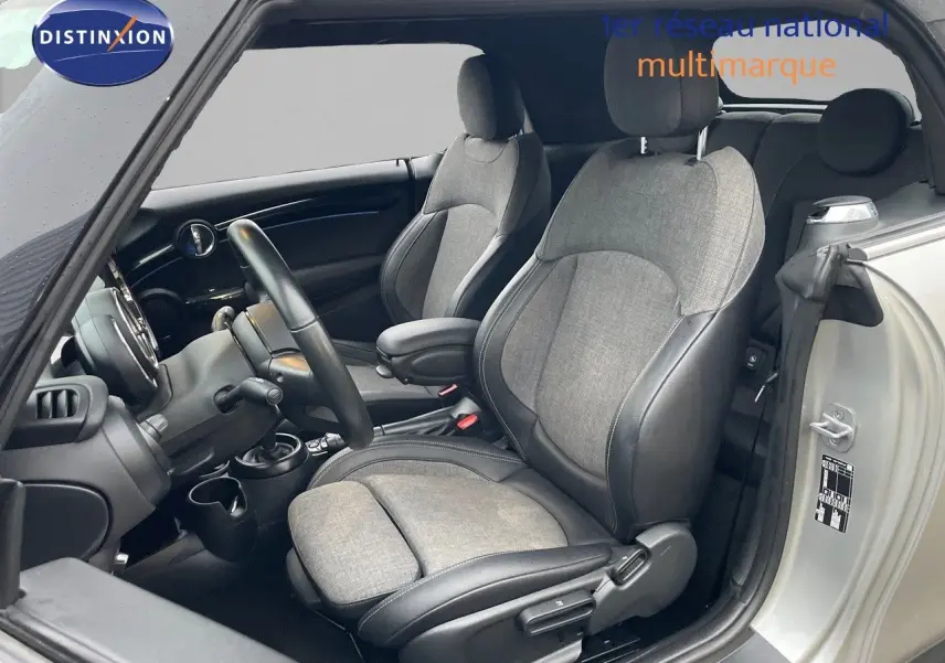 Intérieur de MINI Cabriolet Melting Silver, vue côté gauche sur sièges tissu gris et cuir noir, volant et tableau de bord visibles.