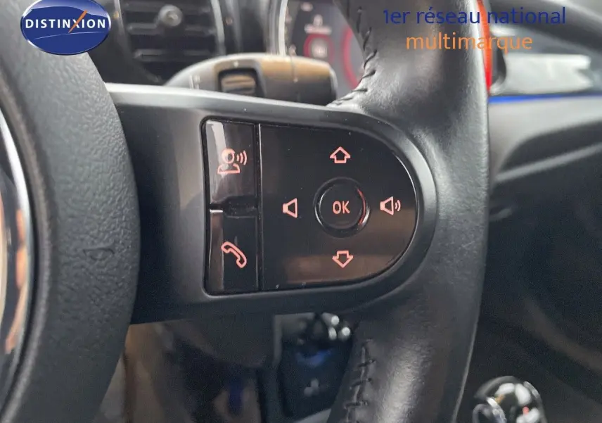 Gros plan sur les commandes au volant en cuir noir de la MINI Cabriolet Melting Silver 2023, avec boutons rétroéclairés.