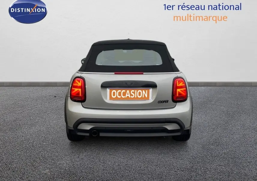 Vue arrière d'une MINI Cabriolet Melting Silver 2023 avec toit noir et feux arrière LED allumés.