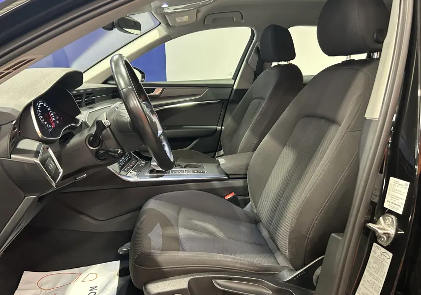 Intérieur noir de l'Audi A6 Avant 40 TDI 2019, vue côté conducteur avec sièges tissu et tableau de bord moderne.