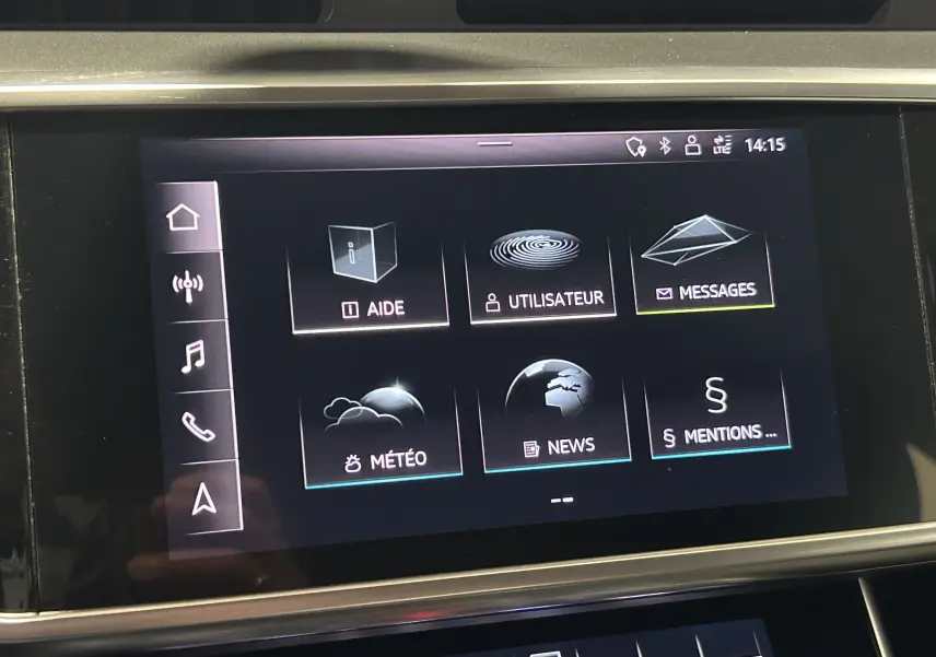 Écran tactile central de l’Audi A6 Avant noir 2019 affichant les menus aide, utilisateur, messages, météo et news.