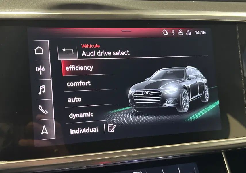 Affichage intérieur du système Audi Drive Select montrant une Audi A6 Avant noire en 3/4 avant droit sur l'écran tactile.