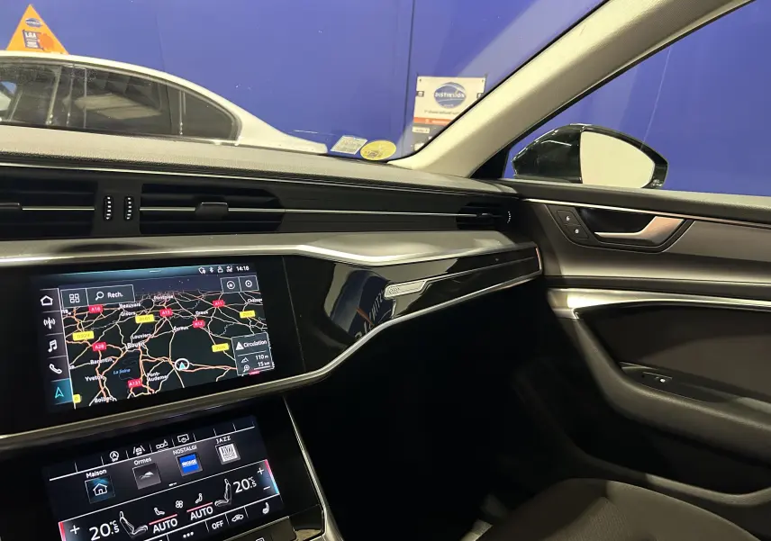 Intérieur de l'Audi A6 Avant 40 TDI 2019 côté passager, tableau de bord noir avec écran tactile et navigation affichée.