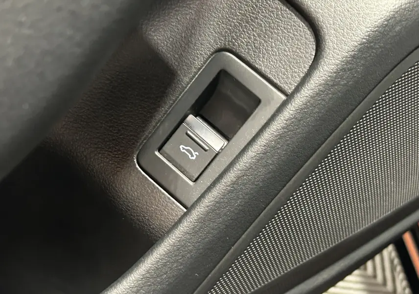 Gros plan sur le bouton d'ouverture du coffre dans l'habitacle noir de l'Audi A6 Avant 40 TDI 2019.