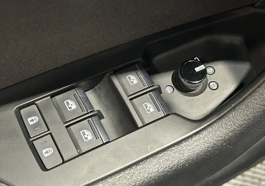 Gros plan sur les commandes de lève-vitres et réglage des rétroviseurs côté conducteur d'une Audi A6 Avant noire 2019.