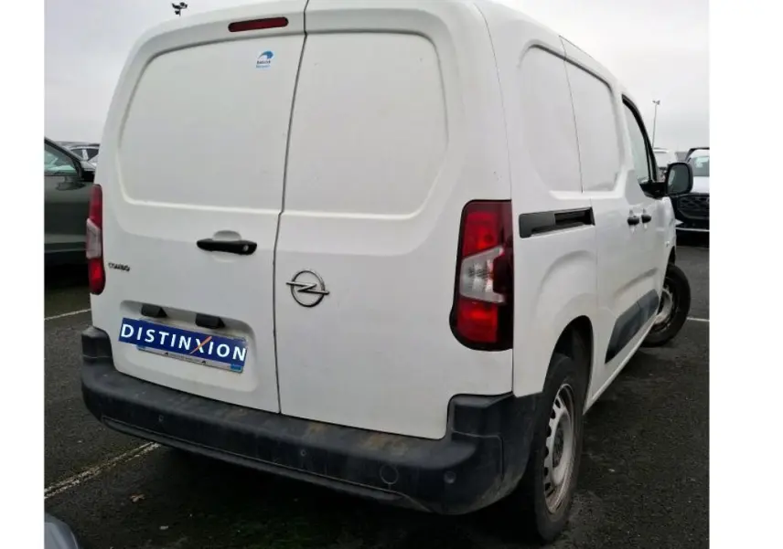 Vue 3/4 arrière droite d’un utilitaire Opel Combo Cargo blanc avec portes arrière battantes et pare-chocs noir.