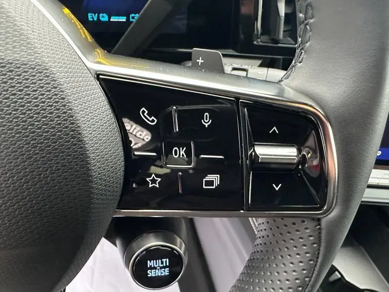 Gros plan sur les commandes au volant du Renault Austral 2025, avec bouton multifonction et molette Multi Sense visible.