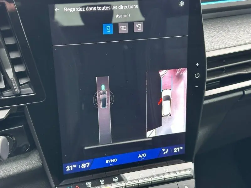 Écran central montrant la caméra 360 du Renault Austral rouge flamme, vue du dessus avec interface de stationnement assisté.