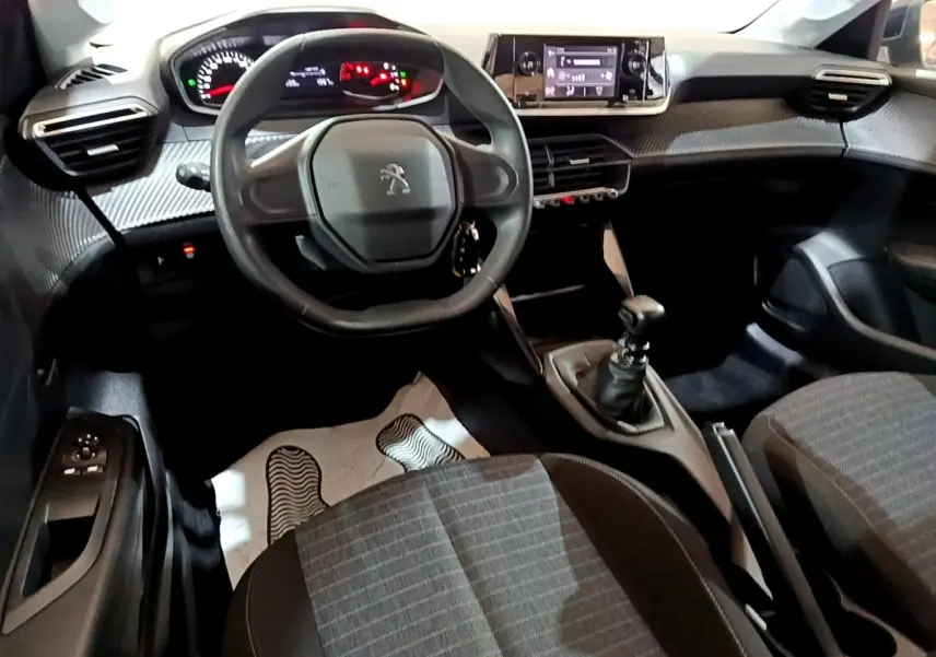 Vue intérieure avant de la Peugeot 208 1.5 BlueHDi 2022, volant compact, tableau de bord numérique et boîte manuelle.
