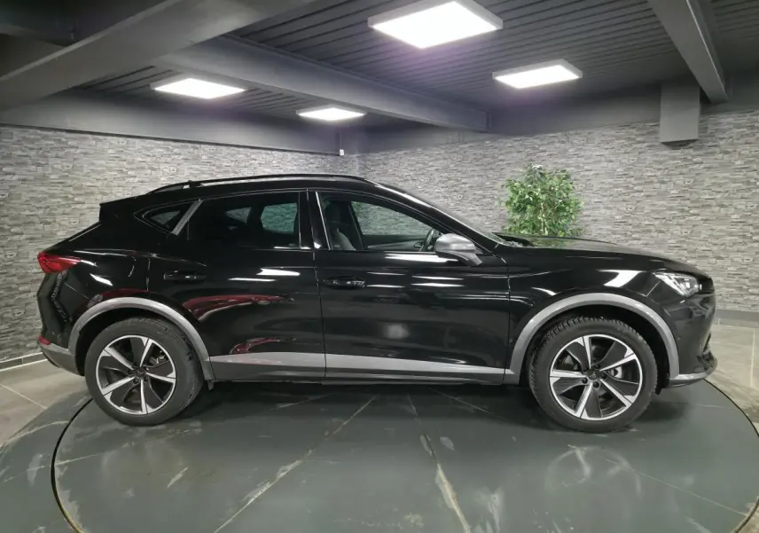 Vue de profil côté gauche d'un CUPRA Formentor noir Minuit avec jantes alliage 18 pouces et détails Dark Alu.