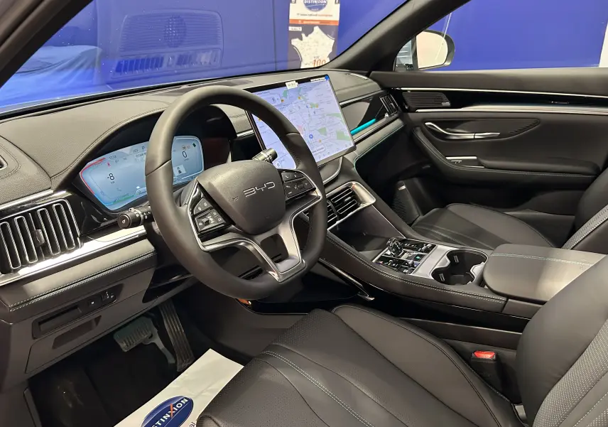 Vue intérieure côté conducteur du BYD SEAL U 2025 avec tableau de bord numérique et écran tactile central, sellerie noire.